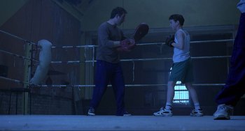Movie still from “The Boxer” (1997), directed by Jim Sheridan – A man and a young boy in a boxing ring; Wide shot, Low angle