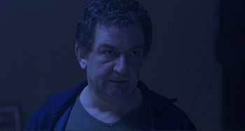 Movie still from “The Boxer” (1997), directed by Jim Sheridan – A person wearing a jacket; Close Up shot, Low angle