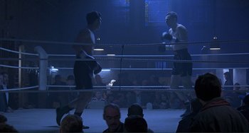 Movie still from “The Boxer” (1997), directed by Jim Sheridan – Two boxers in a boxing ring during a boxing match; Wide shot, High angle