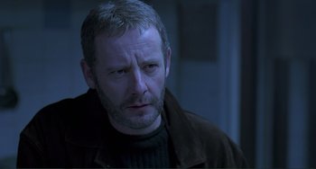 Movie still from “The Boxer” (1997), directed by Jim Sheridan – A person wearing a jacket; Close Up shot, Low angle