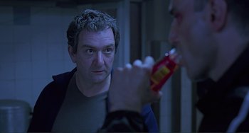 Movie still from “The Boxer” (1997), directed by Jim Sheridan – A man looking at himself in the mirror while brushing his teeth; Close Up shot, Over the shoulder angle