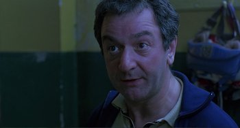 Movie still from “The Boxer” (1997), directed by Jim Sheridan – A person wearing a jacket; Close Up shot, Low angle