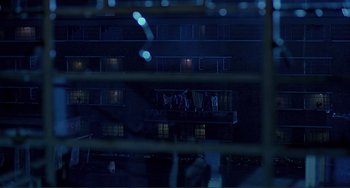 Movie still from “The Boxer” (1997), directed by Jim Sheridan – A group of people standing on top of a balcony; Extreme Wide shot, High angle