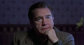 Movie still from “The Boxer” (1997), directed by Jim Sheridan – A person with his hand under his chin; Close Up shot, Low angle