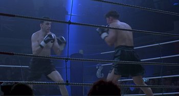 Movie still from “The Boxer” (1997), directed by Jim Sheridan – Two boxers are in the ring during a boxing match; Wide shot, Low angle