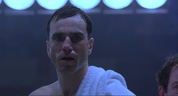 Movie still from “The Boxer” (1997), directed by Jim Sheridan – A person with a towel on his head; Close Up shot, Low angle