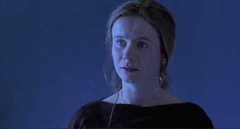 Movie still from “The Boxer” (1997), directed by Jim Sheridan – A young woman is looking into the distance; Close Up shot, Over the shoulder angle