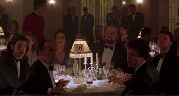 Movie still from “The Boxer” (1997), directed by Jim Sheridan – A group of people sitting around a table with wine glasses; Medium shot, Low angle