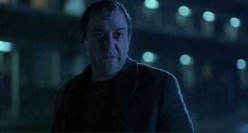 Movie still from “The Boxer” (1997), directed by Jim Sheridan – A person wearing a jacket; Close Up shot, Low angle