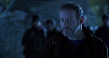 Movie still from “The Boxer” (1997), directed by Jim Sheridan – A person wearing a jacket; Close Up shot, Low angle