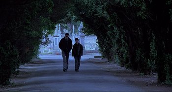 Movie still from “The Boxer” (1997), directed by Jim Sheridan – Two people walking down a street at night; Wide shot, Low angle