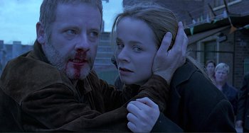Movie still from “The Boxer” (1997), directed by Jim Sheridan – A man and a woman are holding each other's head; Close Up shot, Low angle