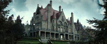 Movie still from “The Boy” (2016), directed by William Brent Bell – An old stone mansion with a red tiled roof; Extreme Wide shot, Low angle