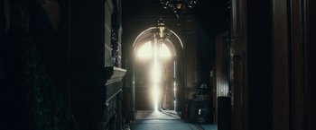 Movie still from “The Boy” (2016), directed by William Brent Bell – A light shining through an arched door way; Wide shot, Low angle