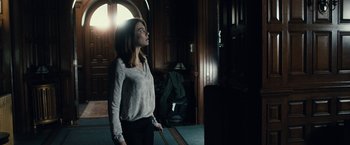 Movie still from “The Boy” (2016), directed by William Brent Bell – A woman standing in front of an open door; Medium shot, Low angle