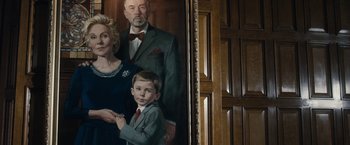 Movie still from “The Boy” (2016), directed by William Brent Bell – A painting of a man , woman , and a boy; Medium shot, Low angle