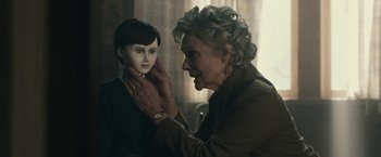 Movie still from “The Boy” (2016), directed by William Brent Bell – An older woman is holding a doll up to her face; Close Up shot, Over the shoulder angle