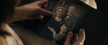 Movie still from “The Boy” (2016), directed by William Brent Bell – A person holding a picture of a family; Extreme Close Up shot, Overhead angle