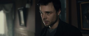 Movie still from “The Boy” (2016), directed by William Brent Bell – A person wearing a jacket; Close Up shot, Over the shoulder angle