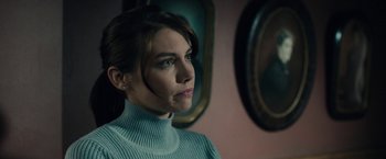 Movie still from “The Boy” (2016), directed by William Brent Bell – A woman in a blue sweater looking at a mirror; Close Up shot, Over the shoulder angle
