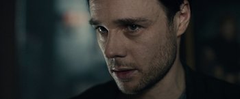 Movie still from “The Boy” (2016), directed by William Brent Bell – A man's face in a black shirt; Close Up shot, Over the shoulder angle