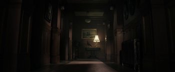 Movie still from “The Boy” (2016), directed by William Brent Bell – A lamp sitting on top of a table in a dark room; Extreme Wide shot, Low angle