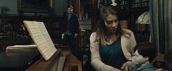 Movie still from “The Boy” (2016), directed by William Brent Bell – A man and a woman playing a piano in a room; Medium shot, Over the shoulder angle