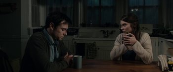 Movie still from “The Boy” (2016), directed by William Brent Bell – Two people sitting at a table with a cup of coffee; Medium shot, Over the shoulder angle