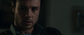 Movie still from “The Boy” (2016), directed by William Brent Bell – A man's face in a dark room; Close Up shot, Over the shoulder angle