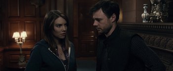 Movie still from “The Boy” (2016), directed by William Brent Bell – A man and a woman standing next to each other in a room; Close Up shot, Over the shoulder angle