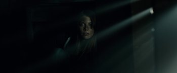 Movie still from “The Boy” (2016), directed by William Brent Bell – A woman in a dark room looking at the camera; Close Up shot, Low angle