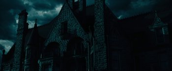 Movie still from “The Boy” (2016), directed by William Brent Bell – A dark picture of an old building with a dark sky; Extreme Wide shot, Low angle