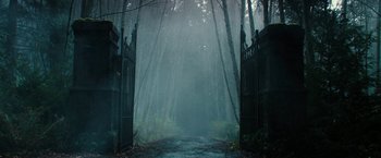Movie still from “The Boy” (2016), directed by William Brent Bell – A path leading through the woods to a gate; Extreme Wide shot, Low angle