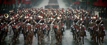 Movie still from “The Brain” (1969), directed by Gérard Oury – A large group of men riding horses in a parade; Extreme Wide shot, High angle