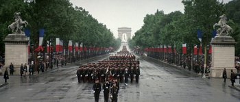 Movie still from “The Brain” (1969), directed by Gérard Oury – A large group of soldiers marching down a street; Extreme Wide shot, High angle