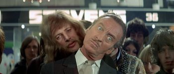 Movie still from “The Brain” (1969), directed by Gérard Oury – A man in a suit and tie next to another man in a suit and tie; Close Up shot, Low angle