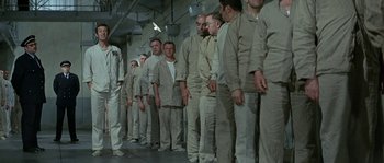 Movie still from “The Brain” (1969), directed by Gérard Oury – A group of men standing next to each other in a room; Wide shot, High angle