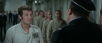 Movie still from “The Brain” (1969), directed by Gérard Oury – A group of men in uniforms standing next to each other in a room; Medium shot, Over the shoulder angle