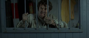 Movie still from “The Brain” (1969), directed by Gérard Oury – A man in a jail cell with his mouth wide open; Medium shot, Low angle