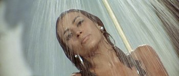 Movie still from “The Brain” (1969), directed by Gérard Oury – A beautiful woman standing under an umbrella in the rain; Close Up shot, Low angle