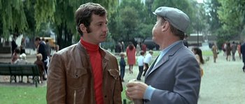Movie still from “The Brain” (1969), directed by Gérard Oury – Two men talking to each other in a park; Medium shot, Low angle