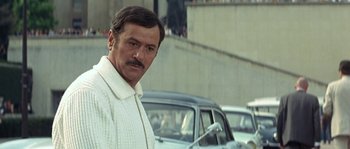 Movie still from “The Brain” (1969), directed by Gérard Oury – A person wearing a white sweater; Close Up shot, Low angle