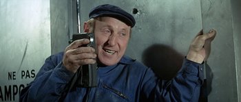 Movie still from “The Brain” (1969), directed by Gérard Oury – An older man holding a cell phone up to his ear; Close Up shot, Low angle