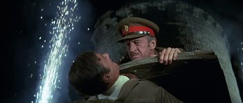 Movie still from “The Brain” (1969), directed by Gérard Oury – A man in a military uniform holding onto another man in a suit; Medium shot, Low angle