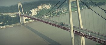 Movie still from “The Brain” (1969), directed by Gérard Oury – A view of a suspension bridge from a distance; Extreme Wide shot, Low angle
