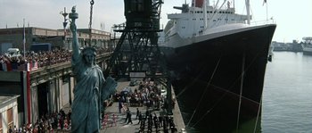 Movie still from “The Brain” (1969), directed by Gérard Oury – A statue of liberty in front of a large ship; Extreme Wide shot, Low angle