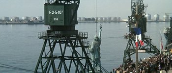 Movie still from “The Brain” (1969), directed by Gérard Oury – The statue of liberty is being lowered into the water; Extreme Wide shot, Low angle