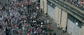 Movie still from “The Brain” (1969), directed by Gérard Oury – An aerial view of a crowd of people walking down a street; Extreme Wide shot, High angle