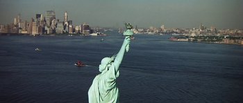 Movie still from “The Brain” (1969), directed by Gérard Oury – The statue of liberty is seen from the air; Extreme Wide shot, Low angle