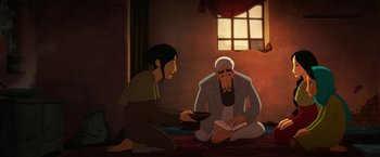 Movie still from “The Breadwinner” (2017), directed by Nora Twomey – An animated scene of a man and a woman sitting on the floor; Wide shot, High angle